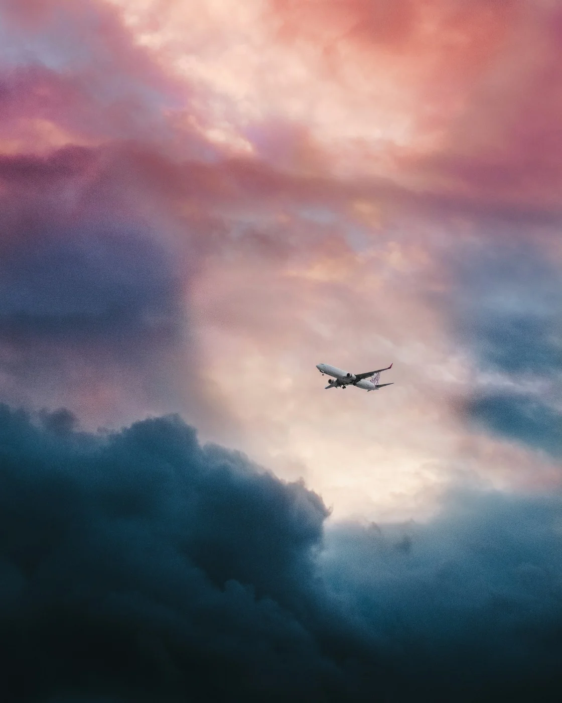 Airplane flying through blue sky, representing the flight from the UK to Canada