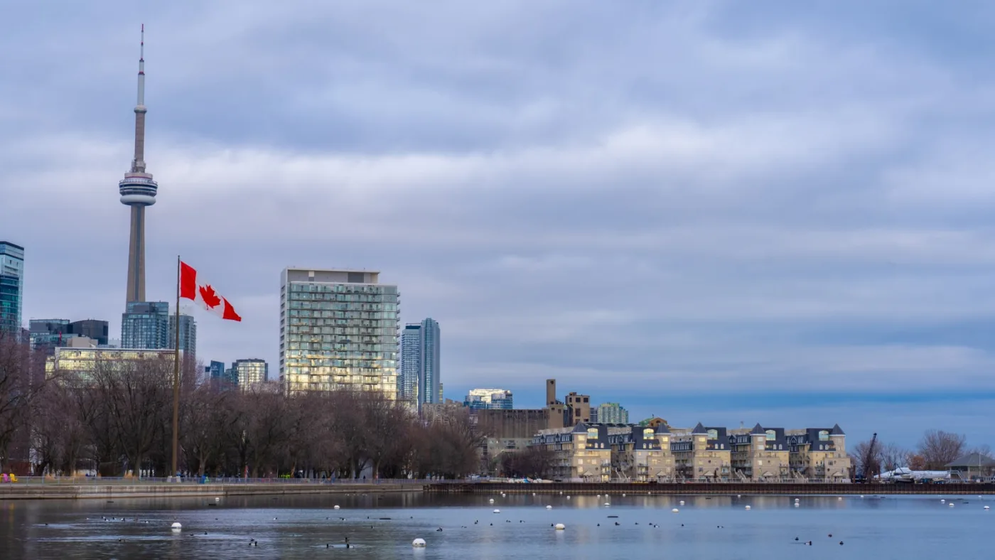 Toronto skyline with Canadian flag representing Express Entry immigration to Canada. CRS Calculator