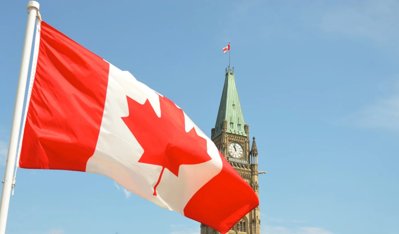 Canadian flag flying against the sky, representing pride in becoming a Canadian citizen