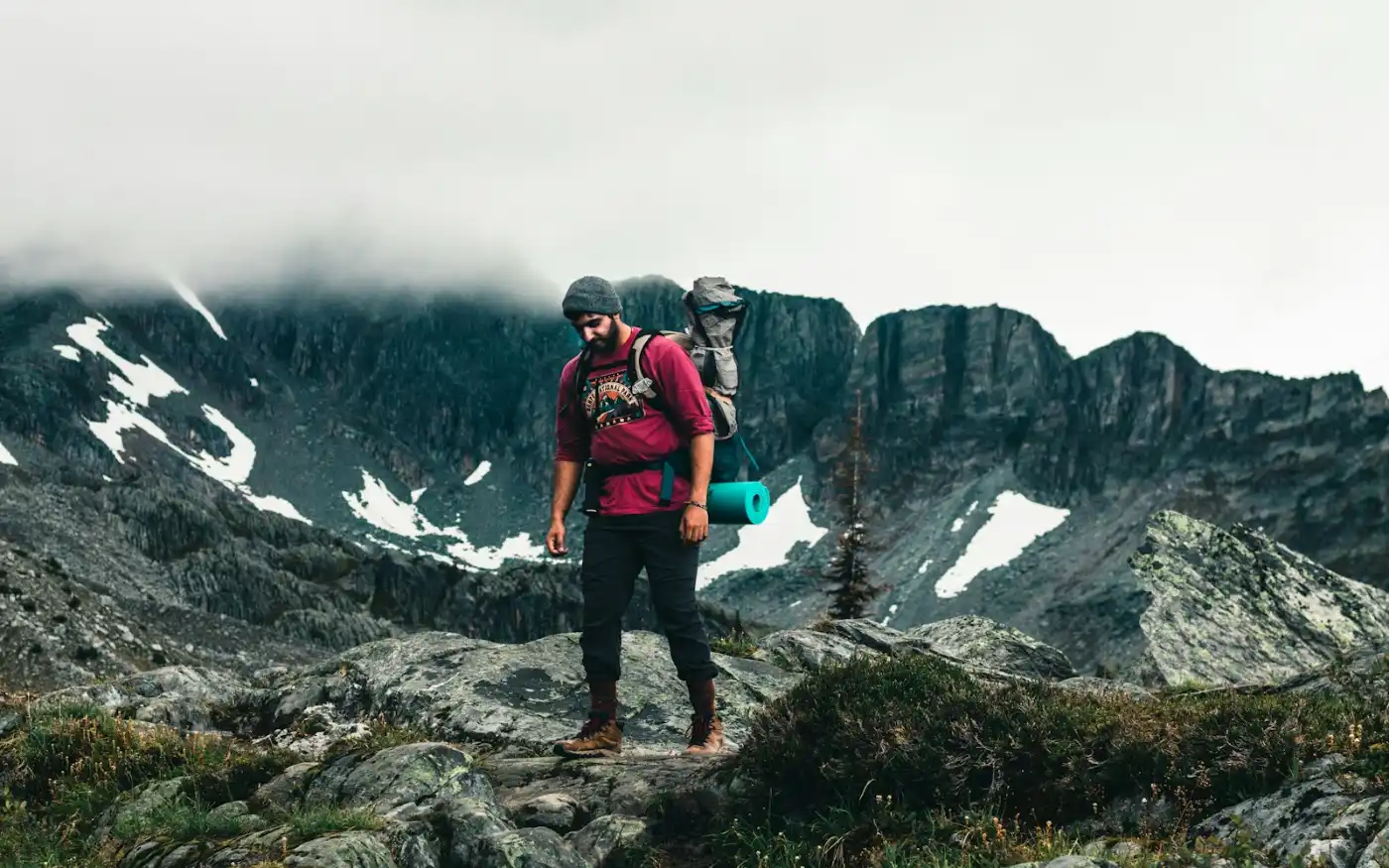 Hiker with backpack trekking through Canadian mountains during a working holiday visa stay
