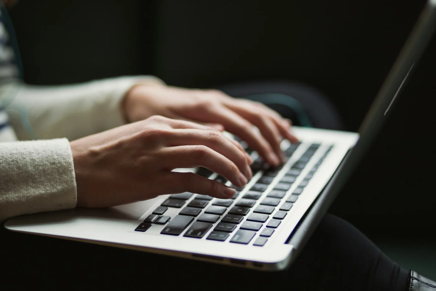 Hands typing on a laptop, representing browsing the latest CRS and immigration news