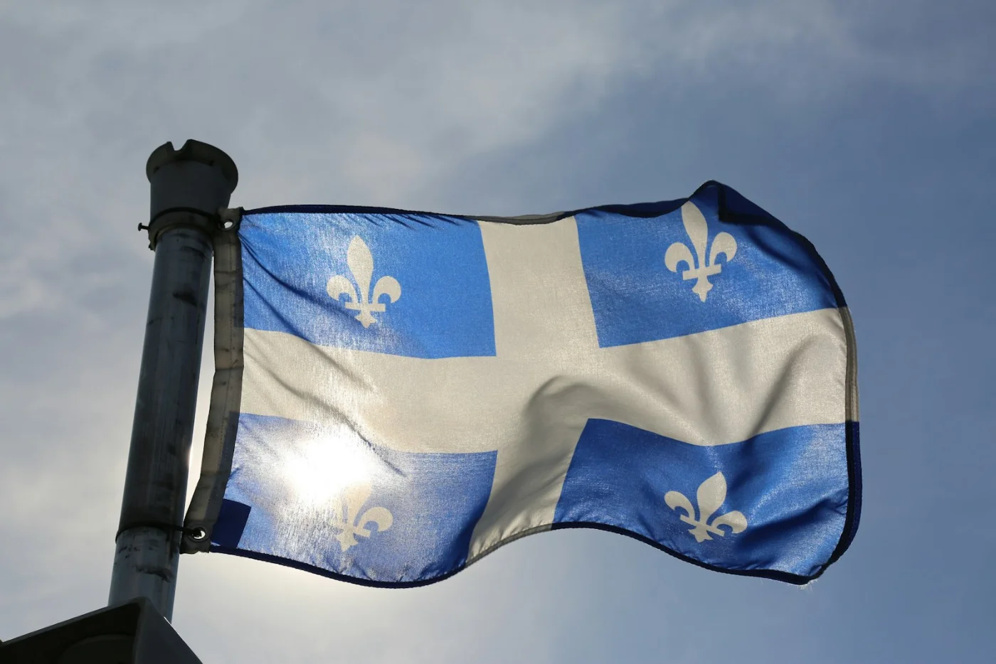 The blue and white fleur-de-lis flag of Quebec, representing the Arrima immigration program