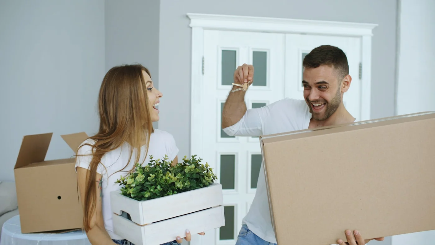 Couple with moving boxes, representing the final step of settling in Canada