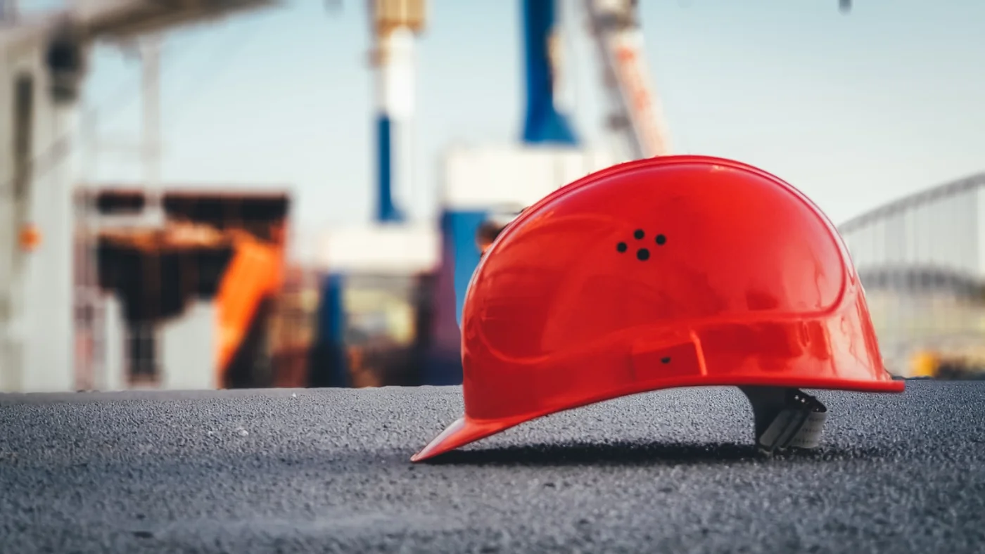 Yellow hard hat and tape measure, representing skilled tradespeople applying for a Canada work visa