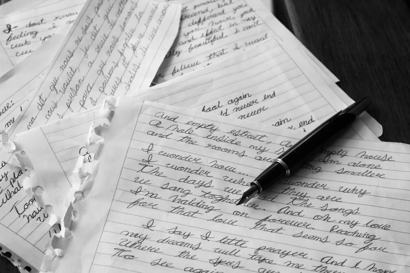 Hand writing on paper, representing the writing portion of the CLB language test
