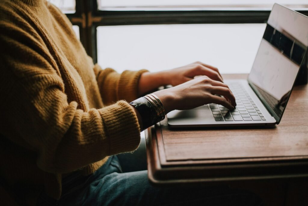 Person typing on a laptop while checking their CRS score and Express Entry profile online