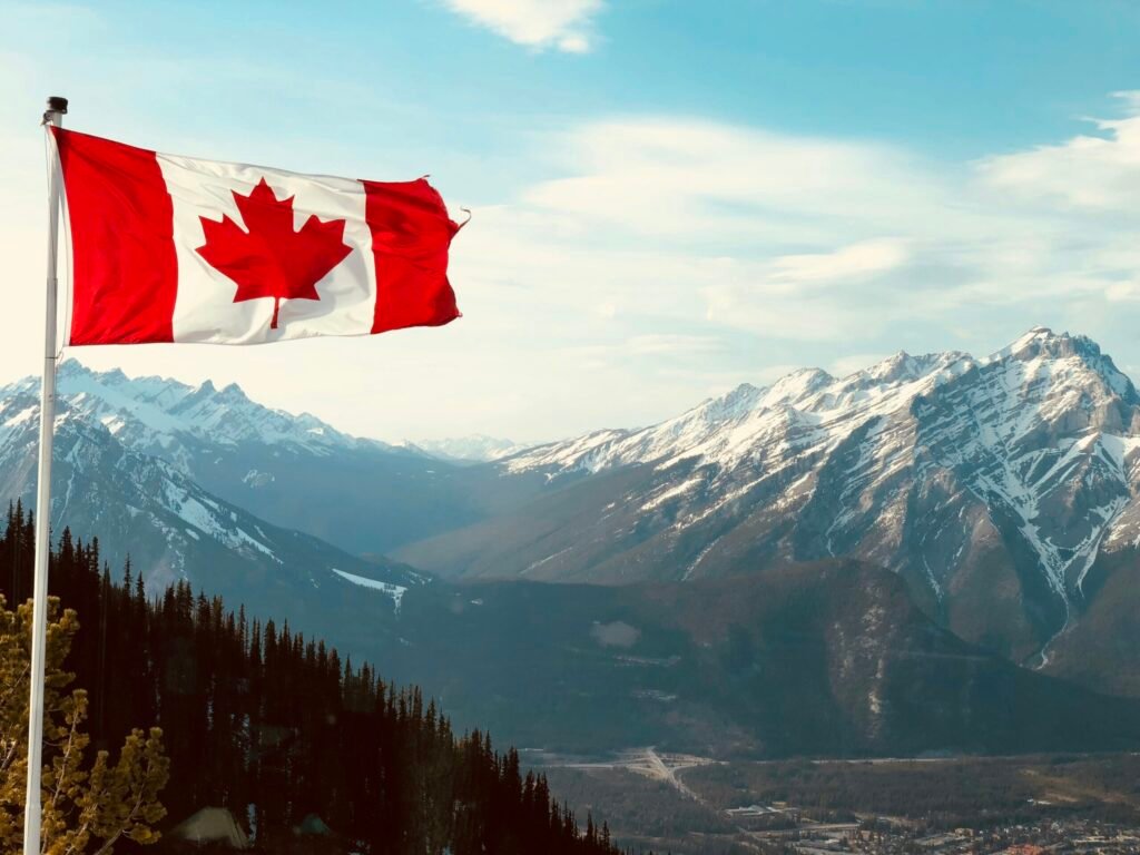 Canadian flag waving against a blue sky, symbolizing permanent residence through Express Entry